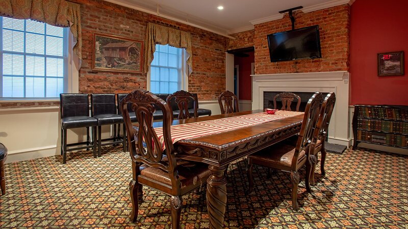 Private meeting room with long table and television mounted on wall