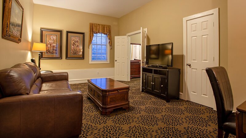Living room with brown leather sofa, coffee table and television on stand
